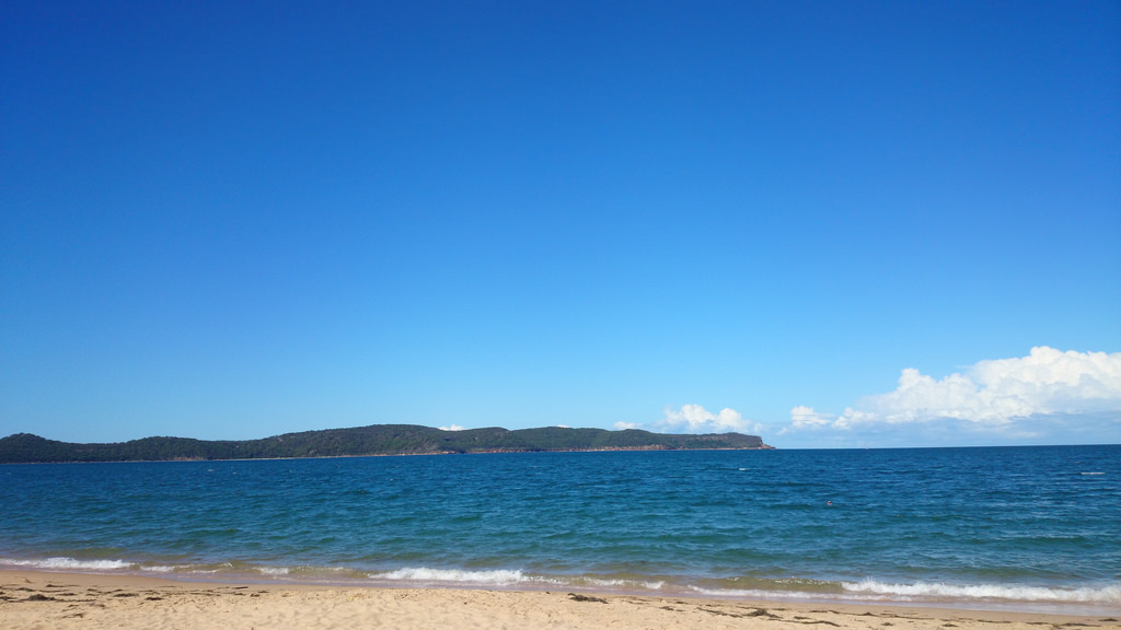 Sandy beach with blue water and blue skies